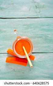 carrot juice on turquoise wooden background