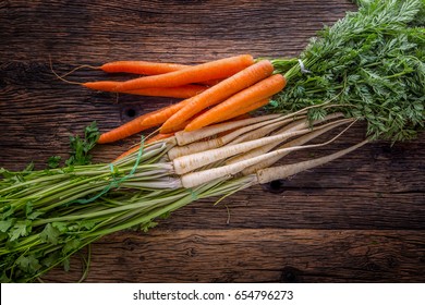 Carrot And Parsnip On Rustic Oak Table.