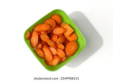 Carrot slices in a green plastic bowl, isolated on a white background - Powered by Shutterstock