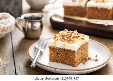 Carrot or spice cake with cream cheese frosting and pecan nuts topped with caramel syrup - Powered by Shutterstock