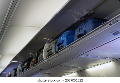 el equipaje de mano se guarda en las papeleras en un avión atestado