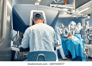 Carrying out an operation using a robot, a robot surgeon with manipulators, a modern operating room, surgeons people perform an operation using a surgeon's robot through the control panel. - Powered by Shutterstock