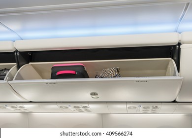 Carry-on Luggage In Overhead Storage Compartment On Airplane.