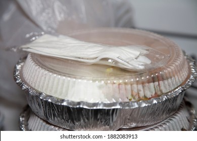 Carryout Tins And Plastic Utensils With A Carryout Bag In The Background