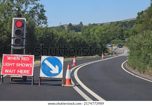 cars approach from the opposite direction\
at roadworks controlled by traffic\
lights
