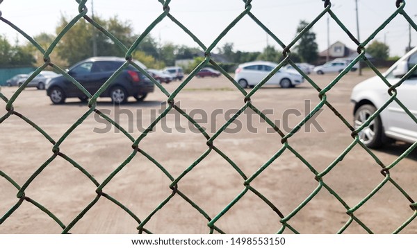 Cars behind a mesh fence. Security, guarded\
parking, fine, arrest\
concept