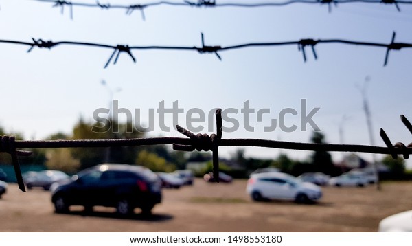 Cars behind a mesh fence. Security, guarded\
parking, fine, arrest\
concept