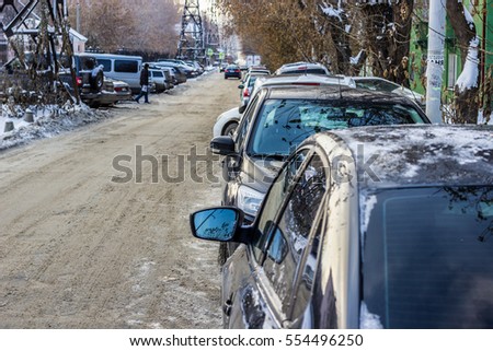Cars in the city, Parking at the roadside. The narrow street. Winter day.