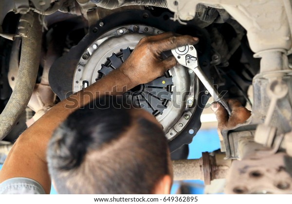 Cars clutch, Automotive\
mechanic tightening using a torque wrench, fixed problem the clutch\
of the car.