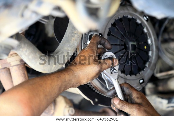 Cars clutch, Automotive\
mechanic tightening using a torque wrench, fixed problem the clutch\
of the car.