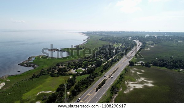 Cars commuting into Tybee\
Island in this aerial view of the gorgeous greenery surrounding the\
coast.