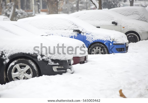 Cars covered with fresh\
white snow