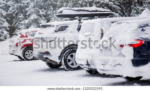 Cars covered with heavy white snow on calamity\
road. Winter car concept in\
storm.