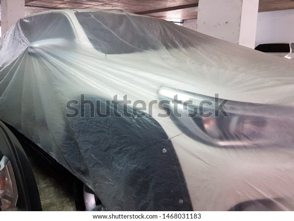 Cars covered with plastic bags To\
prevent dust And prevent dirt Parked in the parking\
building