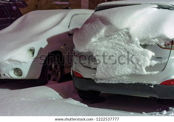 Cars\
are covered with snow after night of snowfall. Snow storm covered\
cars with thick layer of snow. Heavy snowfall created problems for\
drivers. Winter snowstorm. Snow cover.Night\
snowfall