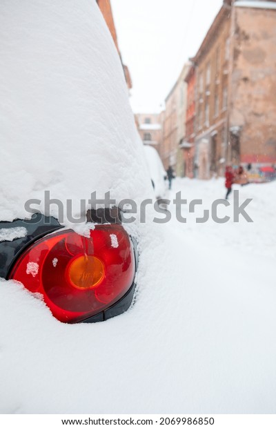 cars covered\
with snow at city streets close\
up