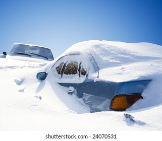 cars covered with snow in the winter blizzard