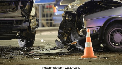 Cars crashed heavily in road accident after collision on city street at night. Road safety and insurance concept