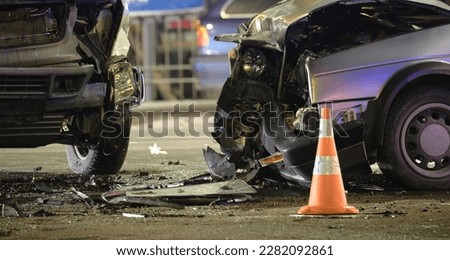 Cars crashed heavily in road accident after collision on city street at night. Road safety and insurance concept