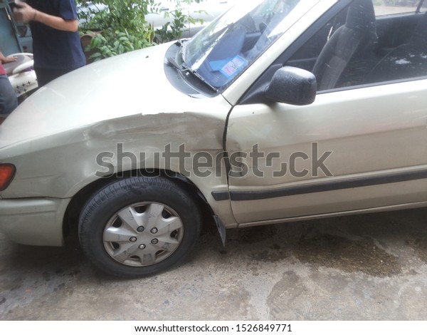 Car\'s dent beside left\
from an accident.