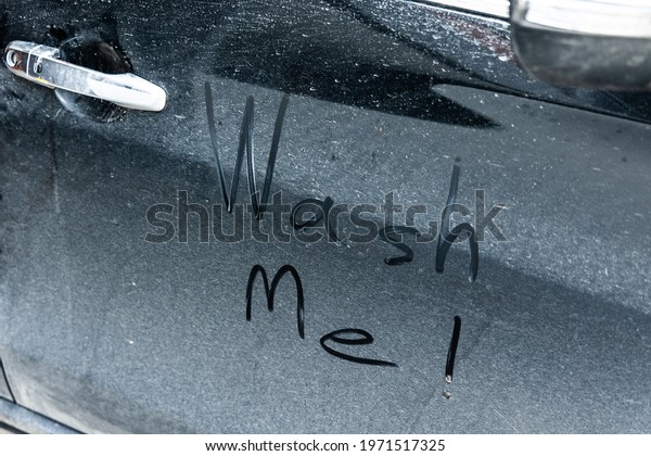 The cars are dirty, muddy, and dusty. It has a message\
saying Wash me