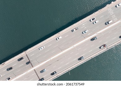 Cars Drive On Road Bridge Over The River, Aerial View.