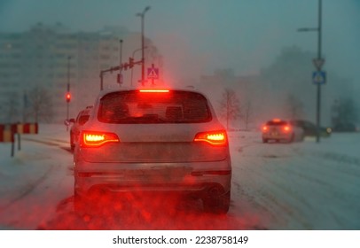 Cars drive on the road in difficult weather conditions. Blizzard.