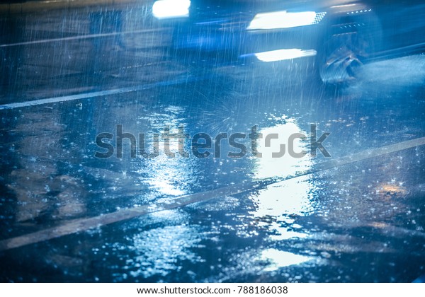 Cars\
driving on wet road in the rain with\
headlights