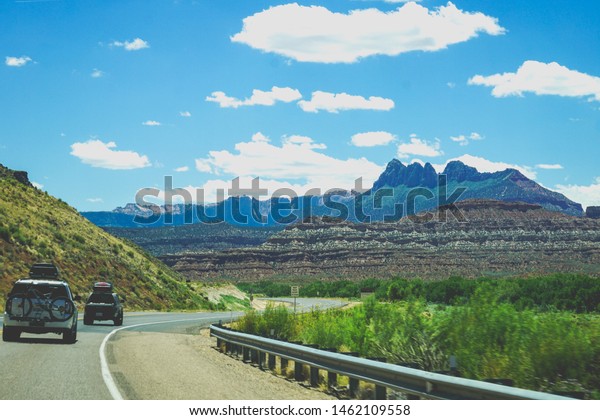 cars driving on\
winding road with\
mountains