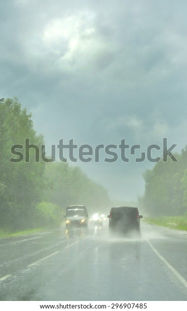 Cars driving in the pouring rain on the highway.
background blur