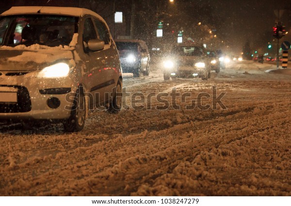 Cars driving in snow blizzard in city by night\
blurry image