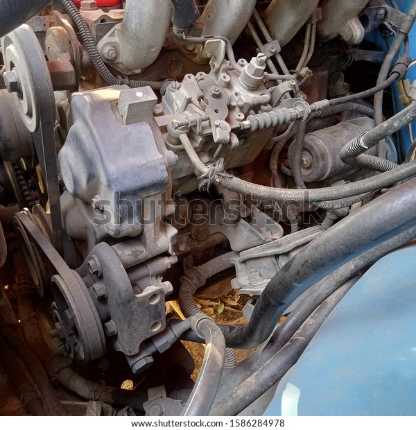 The car\'s\
engine is old and damaged. There is\
dirt.