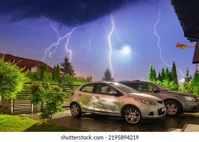 Cars In The Front Driveway During A Lightning Storm At Night