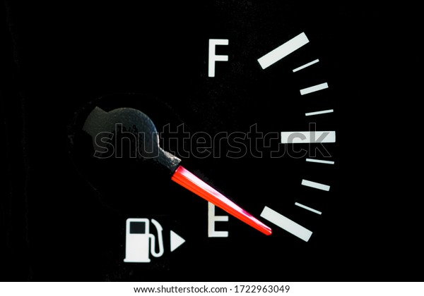 The car\'s fuel gauge shows an empty, close-up,\
black panel, red arrow.
