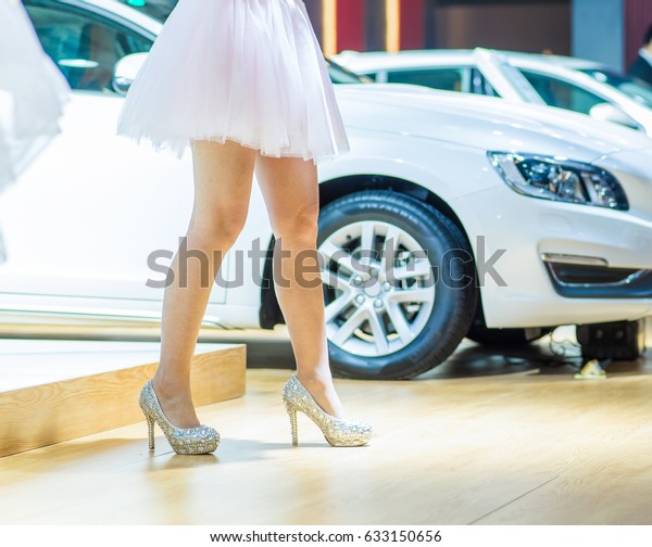 Cars and\
high-heeled sandals in a auto\
show