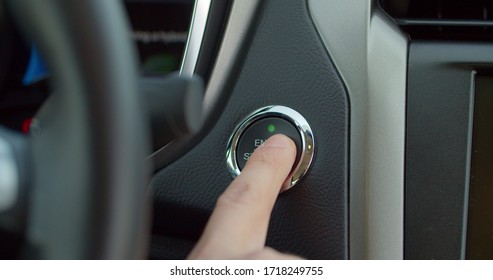 Car's Ignition Button Is Getting Pushed To Start And Stop The Vehicle. Pushing Power Ignition Button To Start Keyless Ignition Hybrid Car Engine.