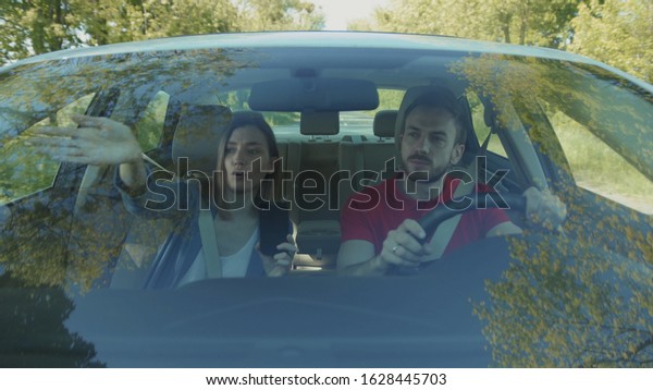 Car's interior. Young Caucasian couple fighting.
Jealousy. Problems in relationship. Summertime. Attractive woman
and boyfriend. Automobile, concept, trip, vacation, safety,
journey, way, metal