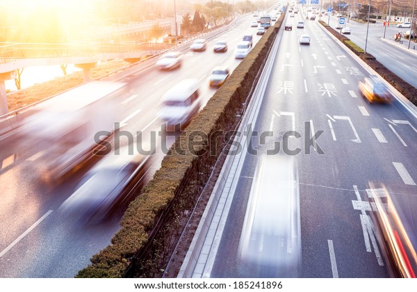 Cars in motion\
blur on street during\
sunset