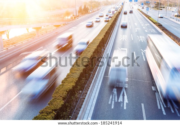Cars in motion\
blur on street during\
sunset