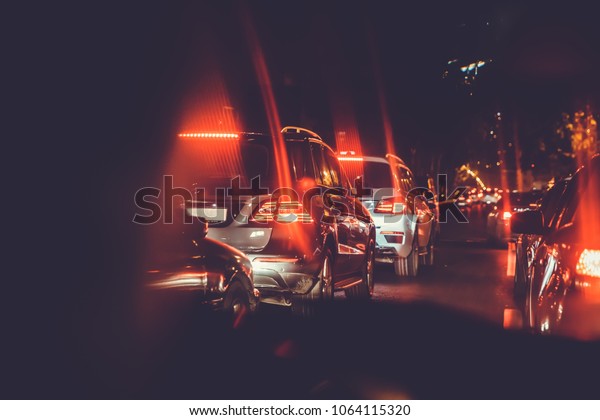 Cars in the night traffic jam . Looking behind the\
cars.Cars are red, yellow night light. Traffic jams in the city\
with row of cars on the road at night and bokeh lights in Baku with\
selective focus 