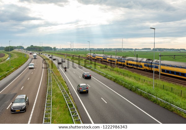 Cars on the A44 highway and a train near the\
village of Abbenes in the\
Netherlands.