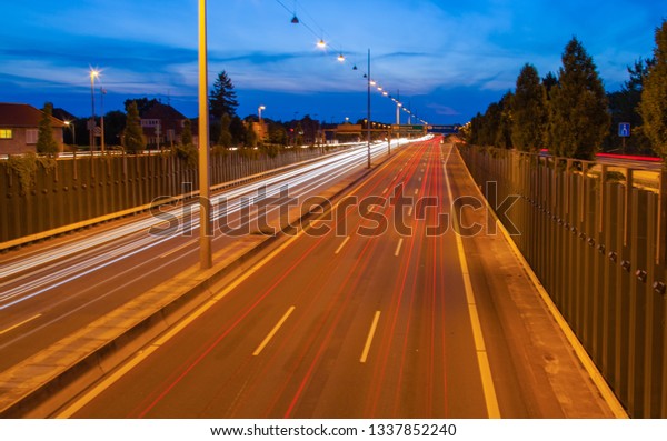 Cars on an\
evening highway rush hour pass as rays of light into a central\
vanishing point due to long\
exposure