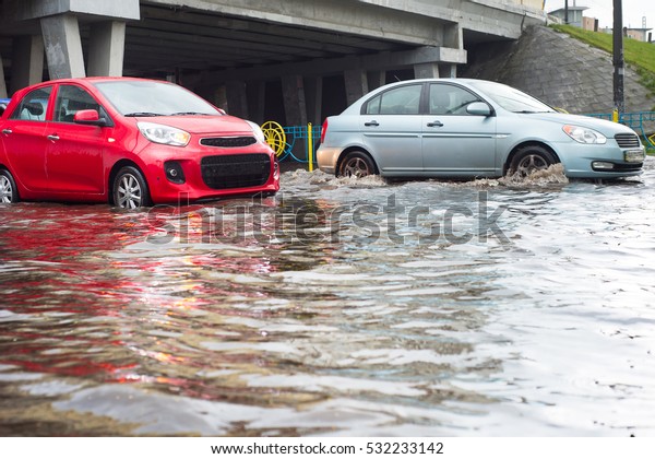 Cars on a flooded\
city road during the rain