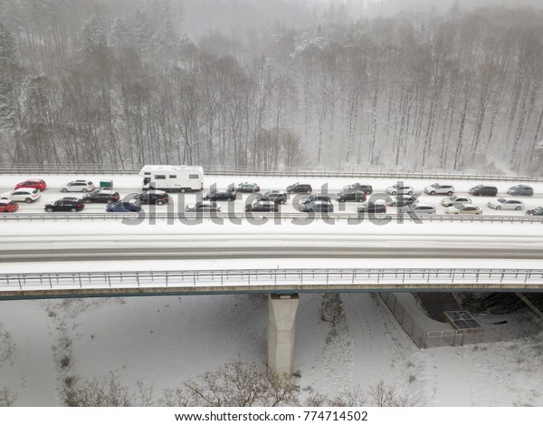 Cars on a highway bridge during a heavy snowfall\
in winter