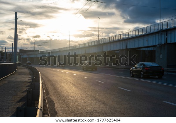 cars on a\
Highway - travel concept. road on the bridge through the city.\
Sunny sky with clouds and beautiful asphalt road in the evening in\
summer. Vintage toning. Travel background.\
