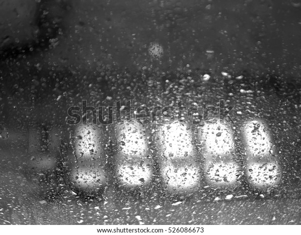 Cars on parking in blur seen through wet window.\
Abstract background 