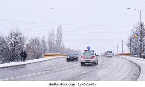 Cars on the road climbing a bridge, driving in difficult weather conditions in winter while snowing in Cluj-Napoca, Romania - January 22, 2019.
