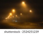 Cars on the road in the fog and drive car carefully.The car is driving along the dangerous foggy road.Traffic danger from fog on highway in the morning time.