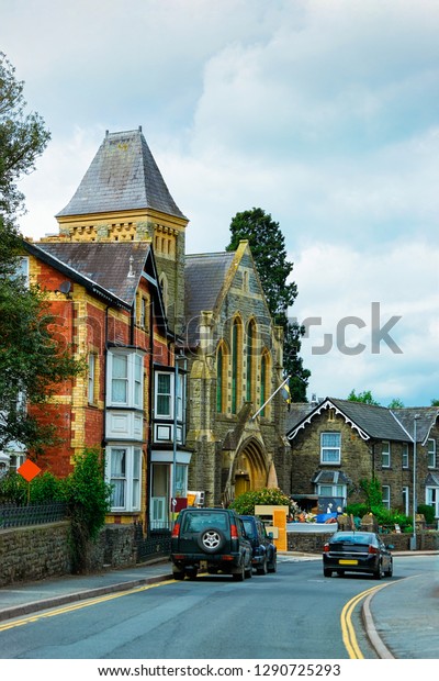 Cars on road and Old building architecture in\
Brecon town in Brecon Beacons National Park in South Wales in\
United Kingdom. In the\
evening