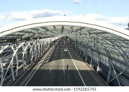 Cars on the road in the sound-absorbing tunnel. Metal structure and glass. Modern technology in the city of Warsaw, Poland.